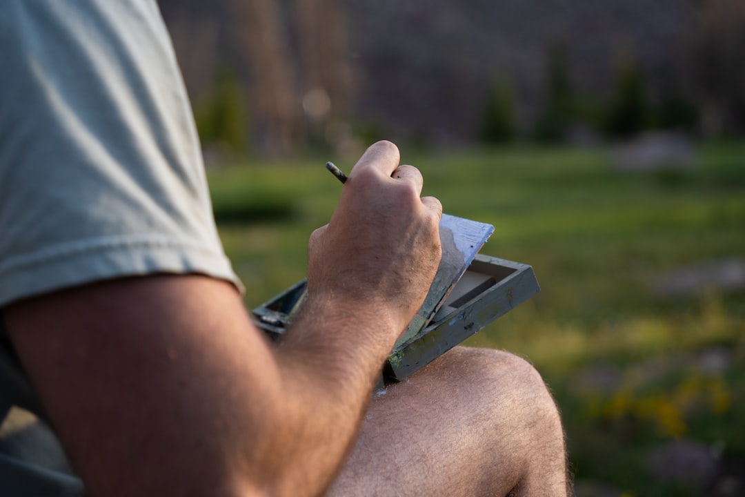 A man sitting in a chair writing on a piece of paper