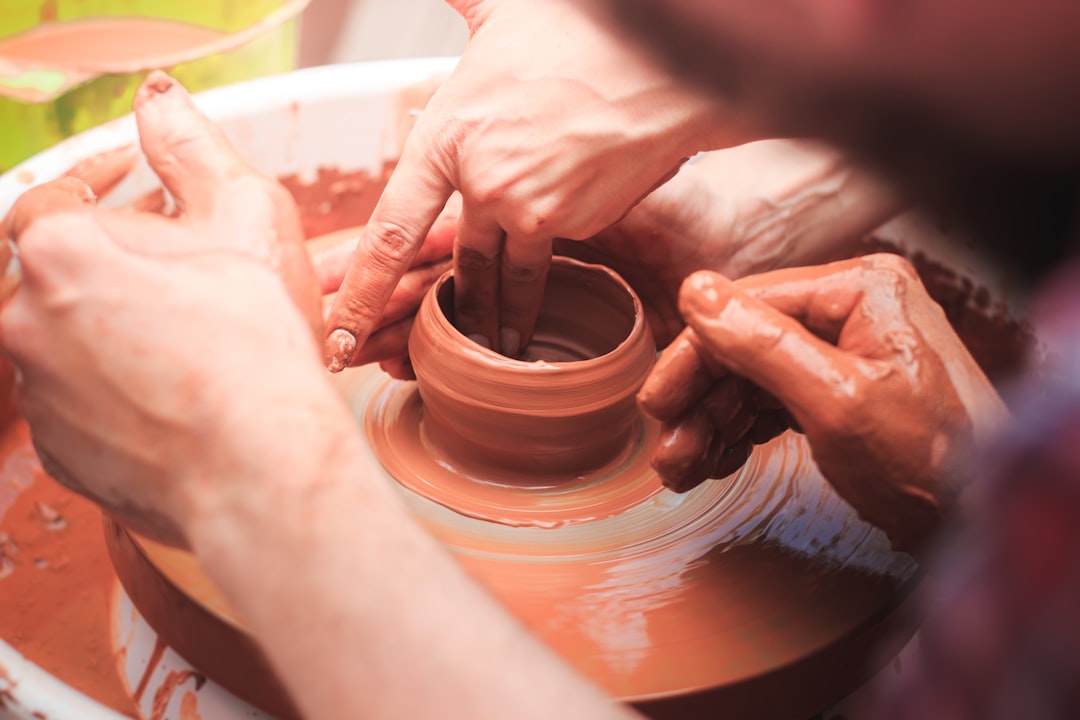 A person is making a vase on a potter's wheel