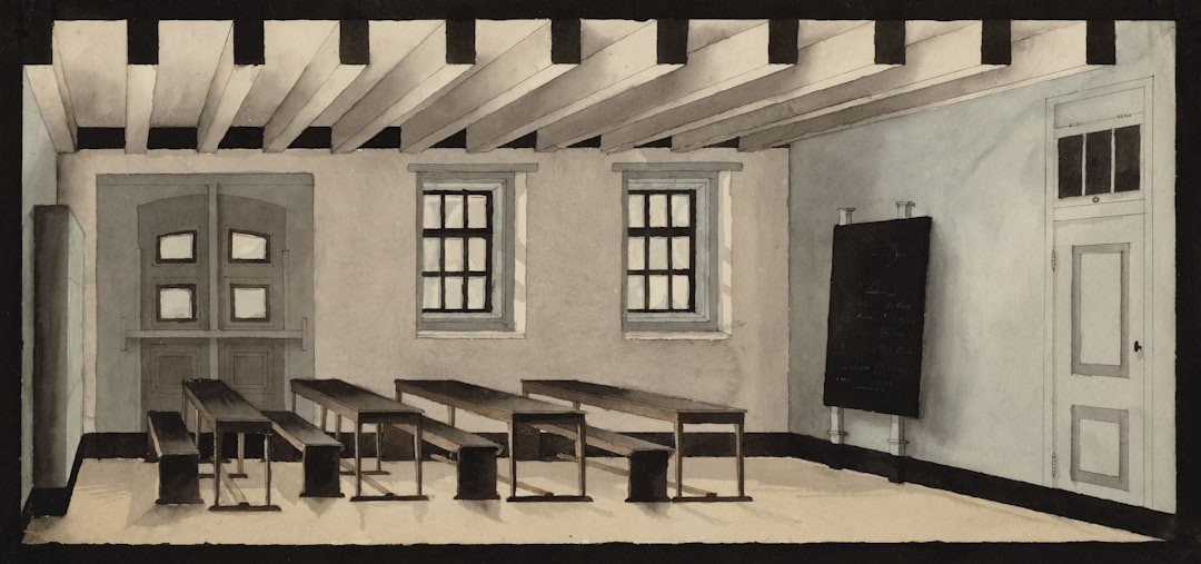 Empty classroom with desks, windows, and blackboard
