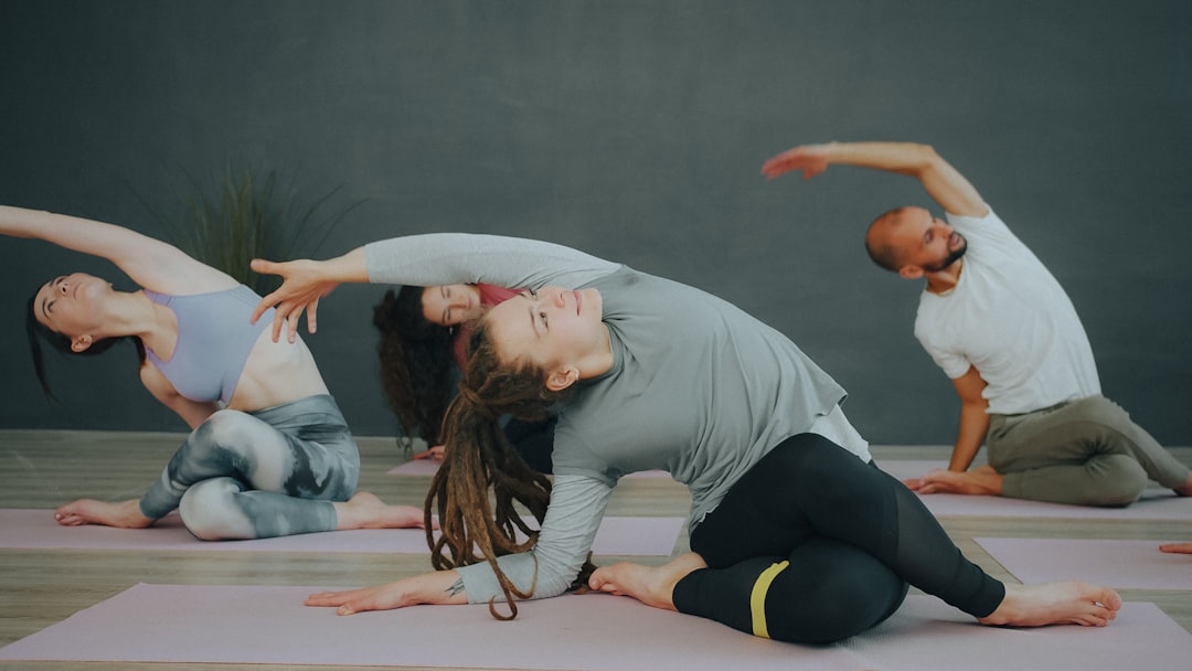 A group of people stretching on yoga mats in a studio